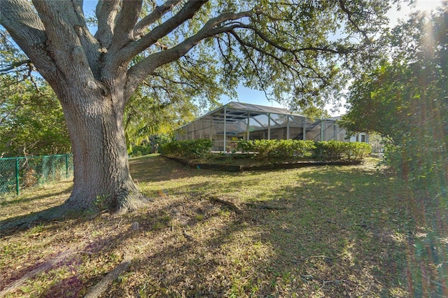 view of yard with fence and a lanai