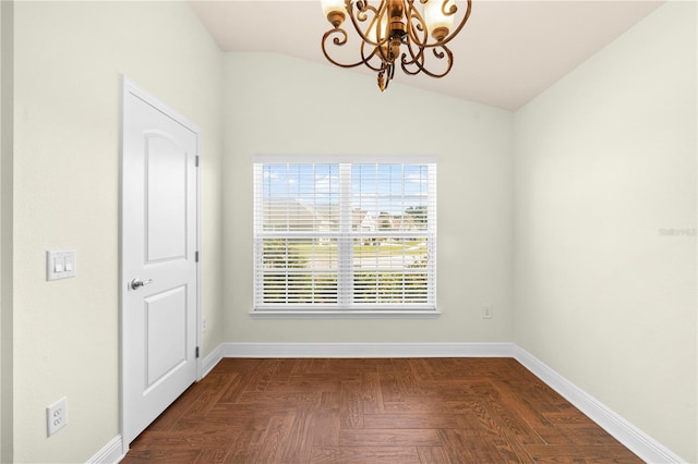 empty room with dark parquet flooring, lofted ceiling, and a notable chandelier