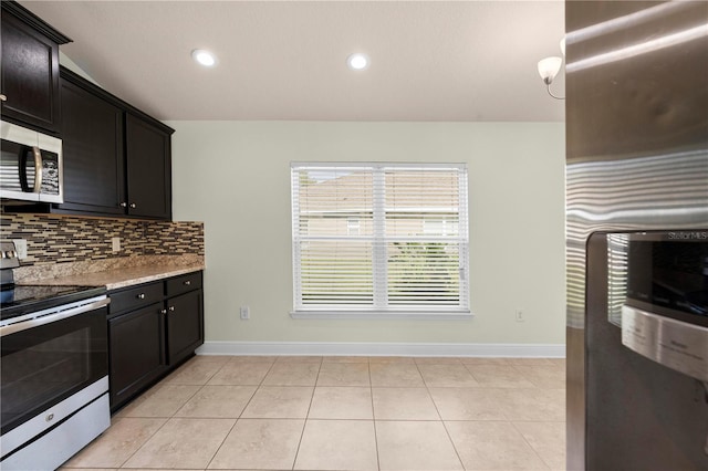 kitchen featuring light stone countertops, appliances with stainless steel finishes, tasteful backsplash, and light tile patterned floors