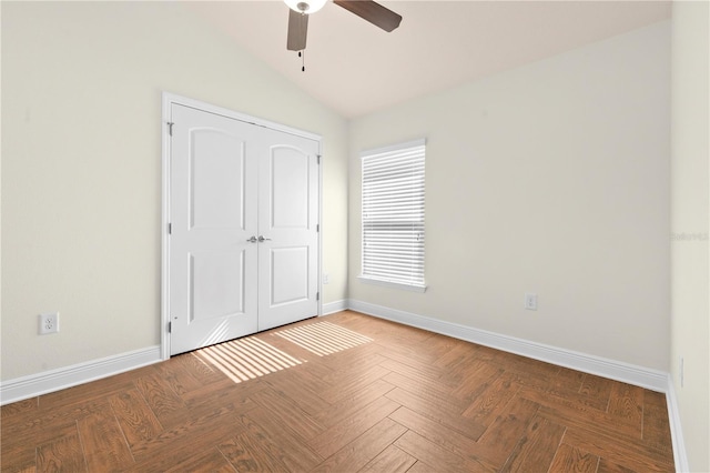 unfurnished bedroom with ceiling fan, lofted ceiling, parquet floors, and a closet