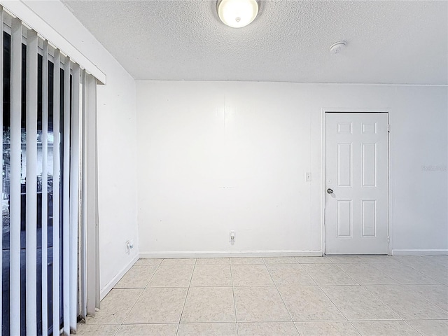 spare room with light tile patterned floors and a textured ceiling