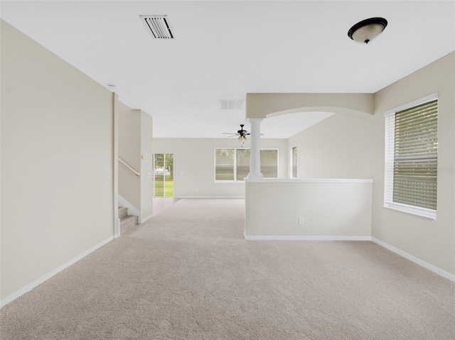 carpeted spare room with ornate columns and ceiling fan