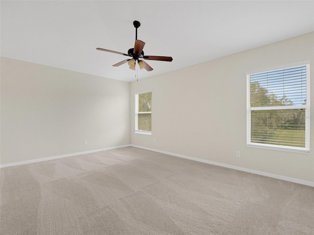 carpeted spare room with plenty of natural light and ceiling fan