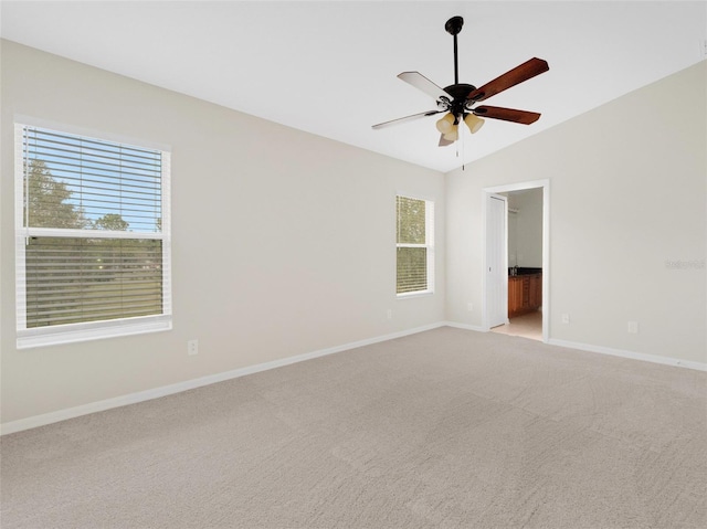 unfurnished room with light carpet, plenty of natural light, ceiling fan, and vaulted ceiling