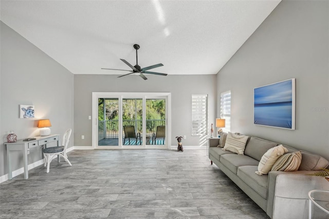 living room featuring a textured ceiling, vaulted ceiling, and ceiling fan