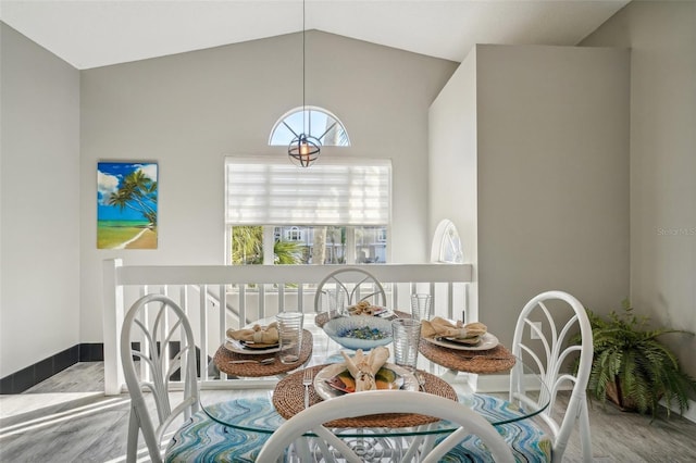 dining area featuring lofted ceiling and light hardwood / wood-style flooring