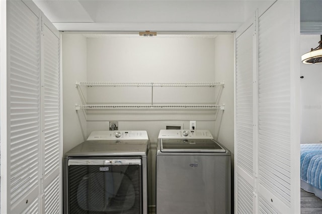 laundry area with washing machine and clothes dryer and hardwood / wood-style floors