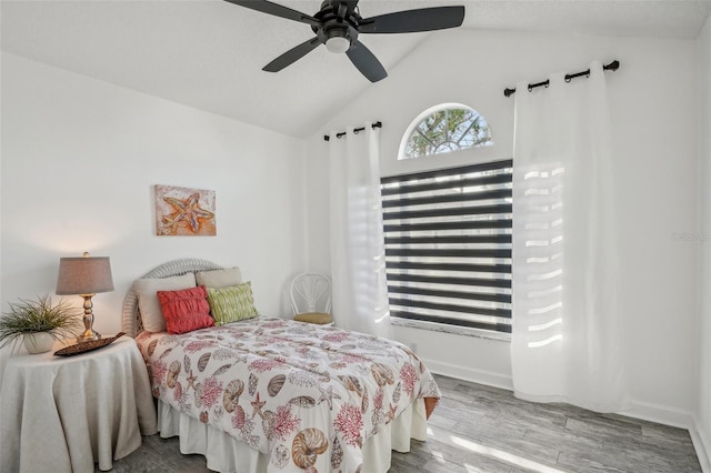 bedroom with ceiling fan, wood-type flooring, and lofted ceiling