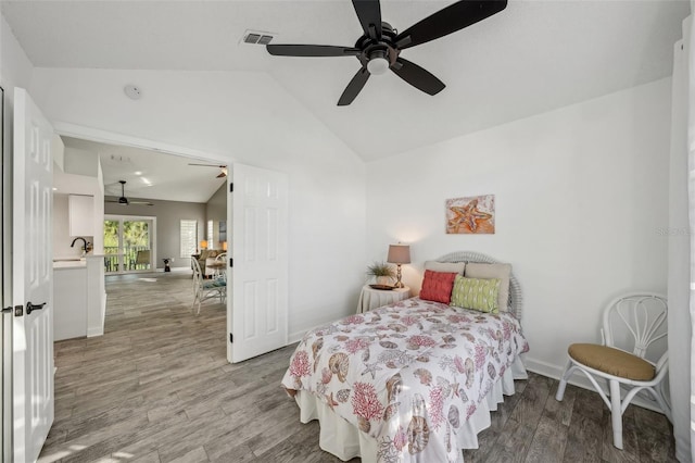 bedroom featuring light hardwood / wood-style flooring, vaulted ceiling, and ceiling fan