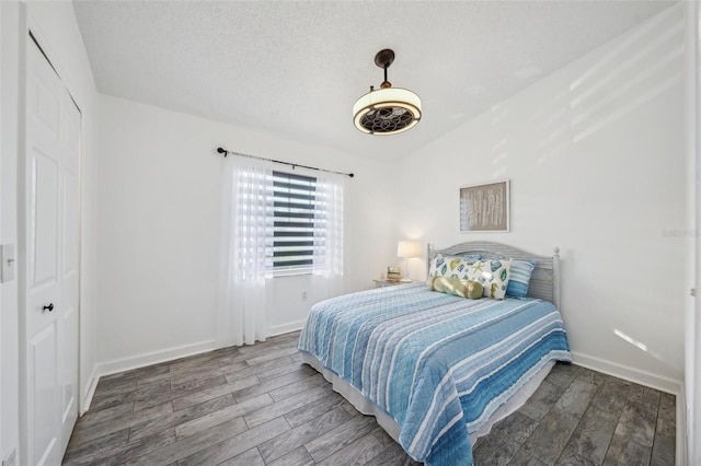 bedroom featuring hardwood / wood-style floors, a closet, lofted ceiling, and ceiling fan