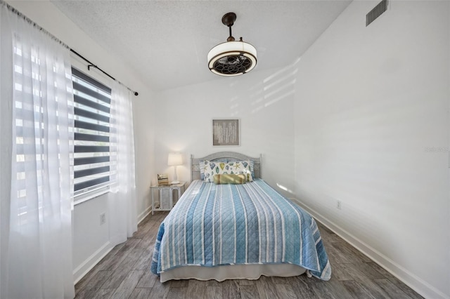 unfurnished bedroom featuring dark hardwood / wood-style floors and lofted ceiling