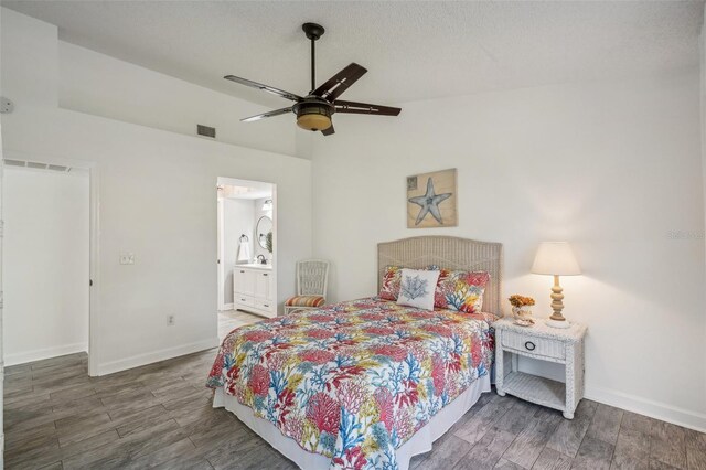 bedroom with ensuite bath, ceiling fan, and dark wood-type flooring