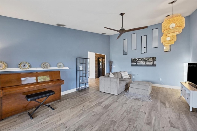 living room with ceiling fan and light hardwood / wood-style flooring