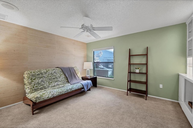 sitting room featuring a textured ceiling, ceiling fan, and carpet flooring