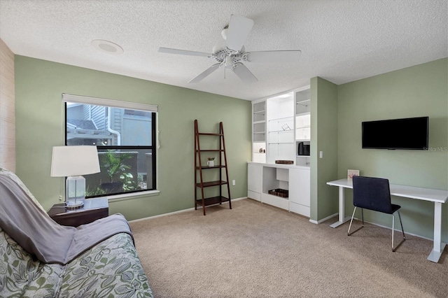 interior space with built in features, light colored carpet, a textured ceiling, and ceiling fan