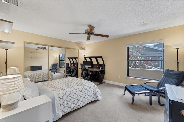 carpeted bedroom featuring a textured ceiling, ceiling fan, and a closet