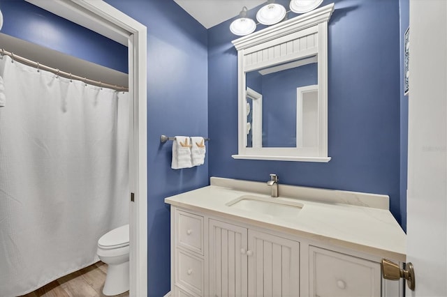 bathroom with hardwood / wood-style flooring, vanity, and toilet