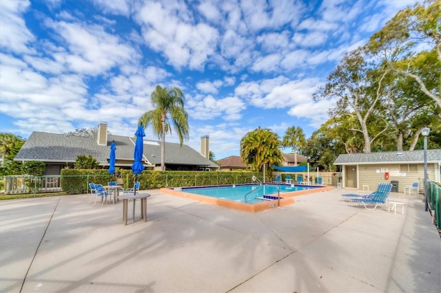 view of pool with an outbuilding and a patio area