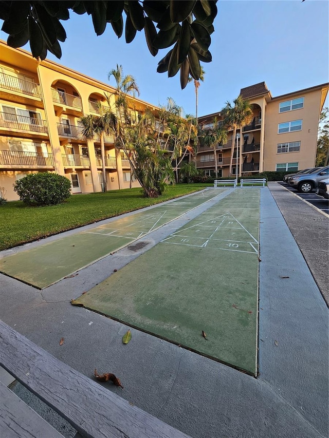 view of home's community featuring a yard and shuffleboard