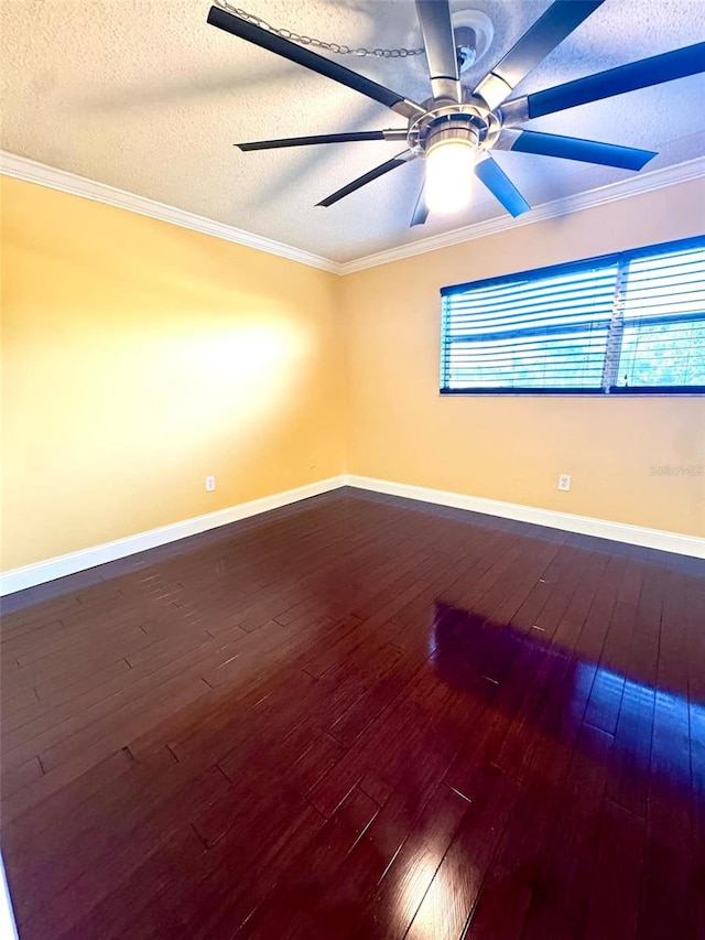 empty room featuring dark wood-style floors, a textured ceiling, baseboards, and crown molding