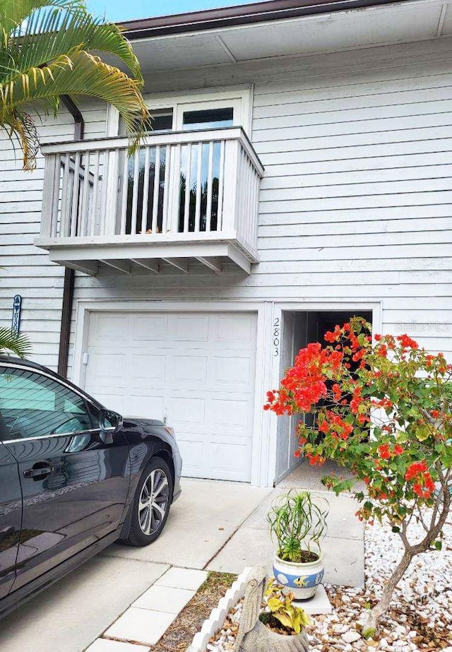 view of side of property with a balcony and a garage