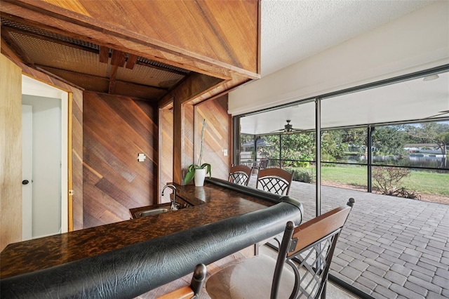 sunroom / solarium featuring ceiling fan, wooden ceiling, and sink