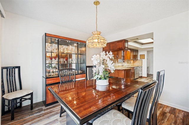 dining space with wood-type flooring and sink