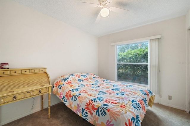 bedroom featuring a textured ceiling, dark carpet, and ceiling fan