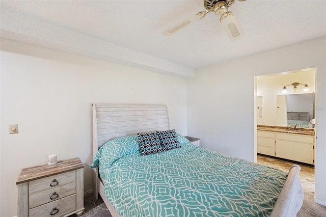 carpeted bedroom featuring ensuite bathroom, sink, ceiling fan, and a textured ceiling