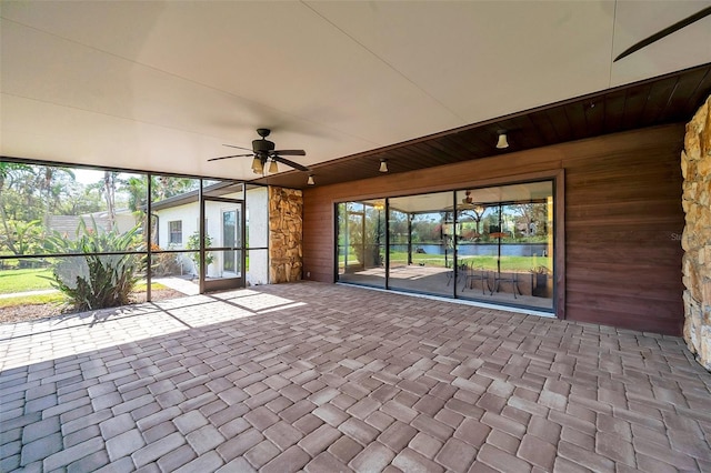 unfurnished sunroom with ceiling fan