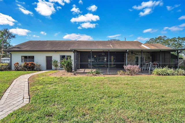 rear view of property with a sunroom and a yard