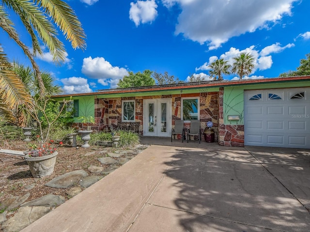 ranch-style home with french doors and a garage