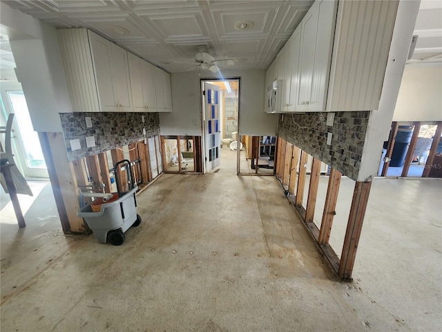 kitchen with ceiling fan, coffered ceiling, and white cabinetry