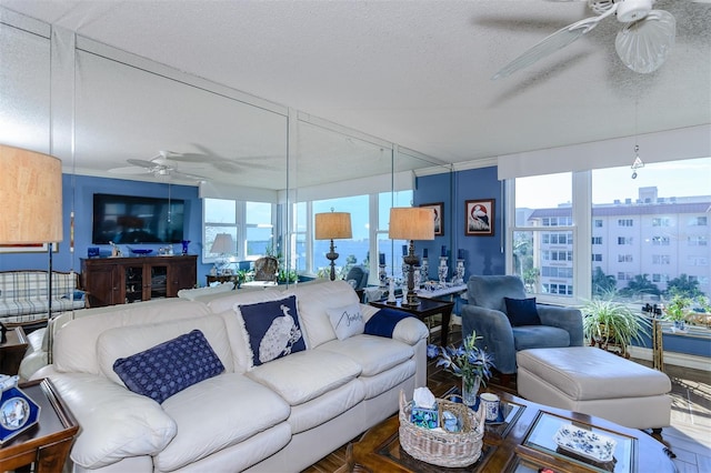 living room featuring ceiling fan and a textured ceiling