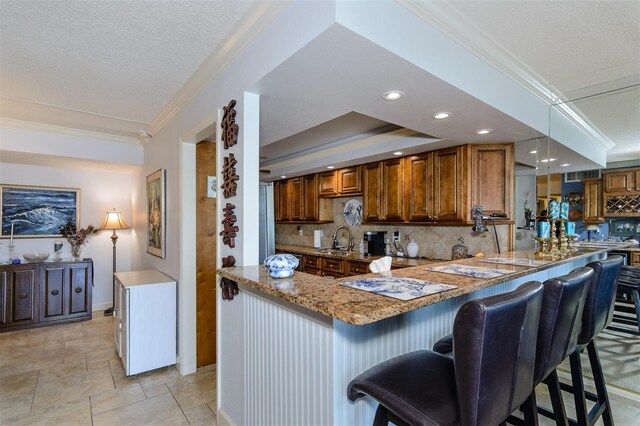 kitchen featuring tasteful backsplash, kitchen peninsula, and a kitchen breakfast bar