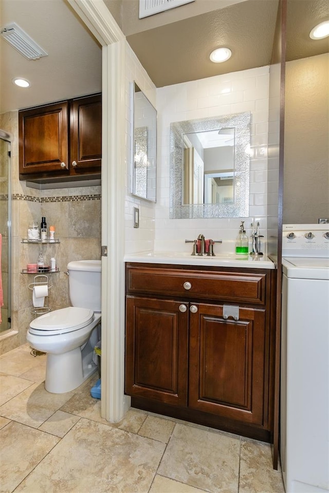 bathroom featuring washer / clothes dryer, toilet, decorative backsplash, vanity, and tile walls