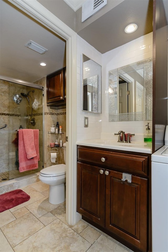 bathroom with vanity, a shower with door, toilet, tasteful backsplash, and washer / clothes dryer