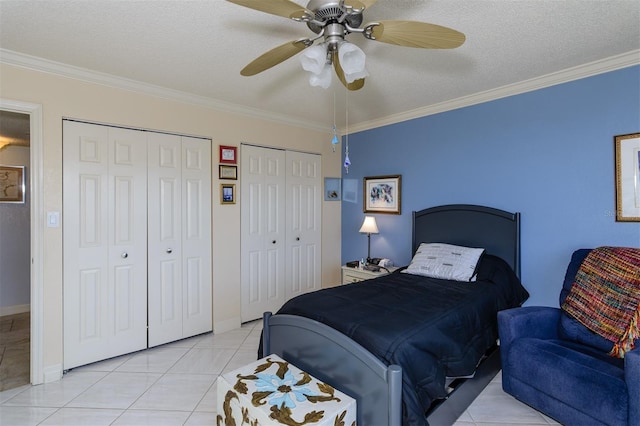 bedroom featuring a textured ceiling, two closets, ceiling fan, and crown molding