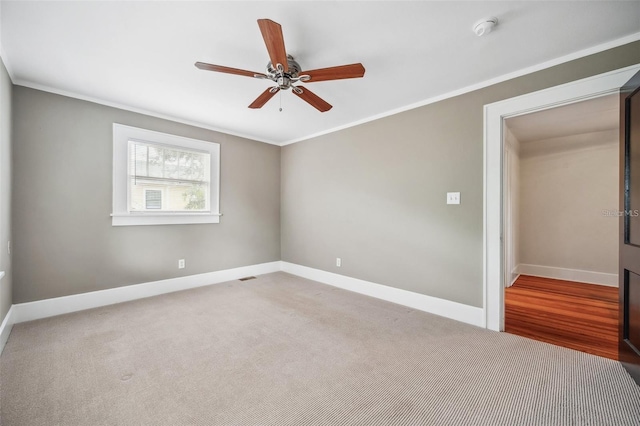 carpeted spare room featuring ornamental molding and ceiling fan