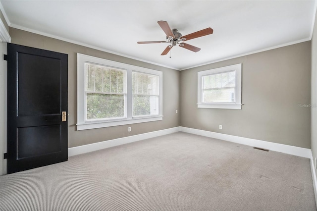 unfurnished room featuring crown molding, ceiling fan, light carpet, and a wealth of natural light