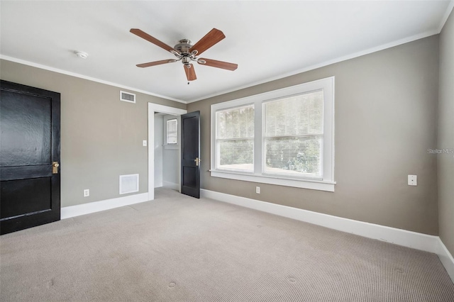 unfurnished bedroom with ornamental molding, light carpet, and ceiling fan