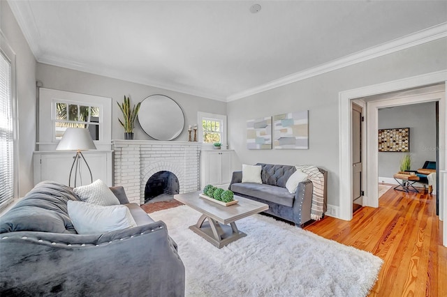 living room with ornamental molding, a healthy amount of sunlight, and light wood-type flooring