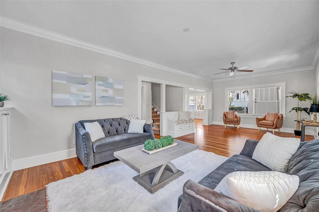 living room with hardwood / wood-style flooring, ceiling fan, and crown molding