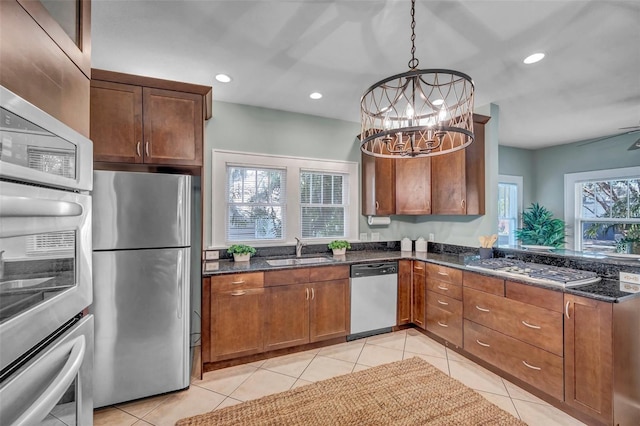 kitchen with pendant lighting, sink, a wealth of natural light, and stainless steel appliances