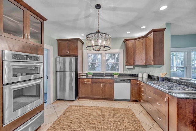 kitchen featuring hanging light fixtures, light tile patterned floors, a wealth of natural light, and appliances with stainless steel finishes