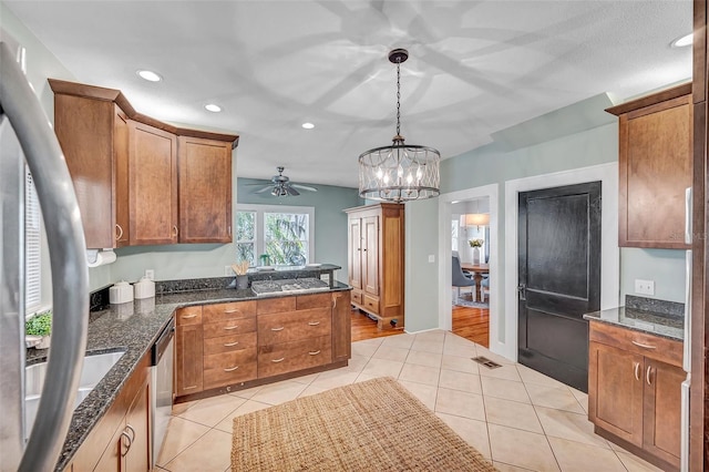 kitchen with stainless steel appliances, ceiling fan with notable chandelier, light tile patterned floors, and decorative light fixtures