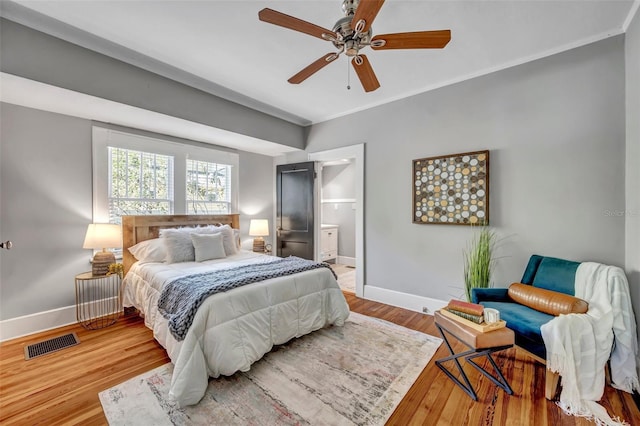 bedroom with crown molding, light hardwood / wood-style flooring, ceiling fan, and ensuite bathroom