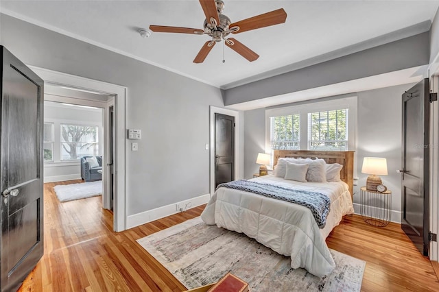 bedroom with multiple windows, light wood-type flooring, and ceiling fan