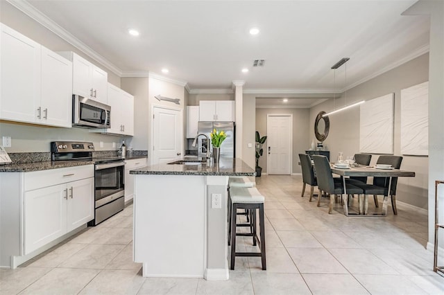 kitchen featuring a center island with sink, sink, white cabinetry, and stainless steel appliances