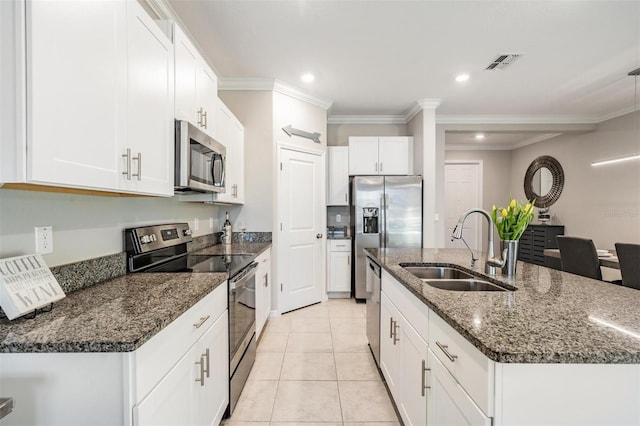 kitchen with stainless steel appliances, crown molding, sink, a center island with sink, and white cabinetry